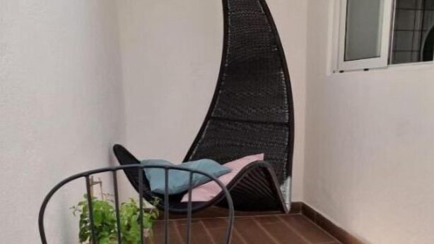 A small balcony with a table, chairs, and a hanging chair. - Dream Day Cottages #5
 (Tutu)