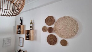 A room with a wooden wine rack, a woven wall hanging, and a ceiling light fixture. - Dream Day Cottages #5
 (Tutu)