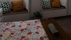 A room with a bed, a window seat with cushions, and a view of the outside. - Dream Day Cottages #7
 (Tutu)