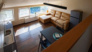 A modern kitchen with a dining area, a sofa, and a refrigerator. - Vista Paradiso - Appartamento "zannone" (Lazio)