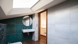 A modern bathroom with a skylight, a sink, and a mirror. - Vista Paradiso - Appartamento "zannone" (Lazio)