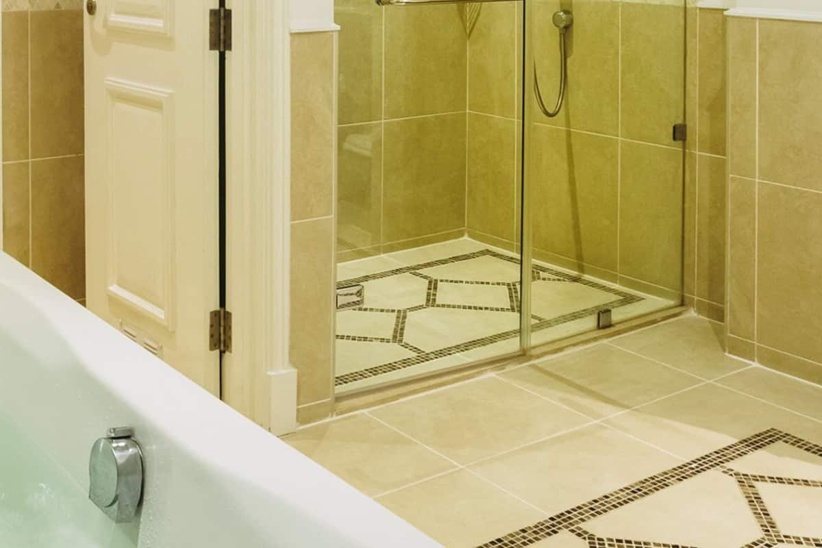 A bathroom with a bathtub, a shower, and a glass-enclosed shower area.
