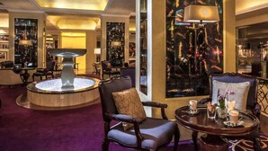 A lobby with a central fountain, seating areas, and a large decorative wall. - Travelers Safari - Westlands (Nairobi)
