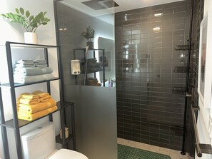 Premier studio | Badkamer | Een douche, een regendouche, een haardroger, handdoeken