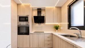 Une cuisine moderne dotée d’appareils électroménagers intégrés, d’un évier et d’une fenêtre.