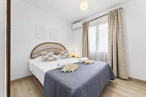 Habitación de hotel ordenada con cama, mesitas de noche y una ventana con cortinas.