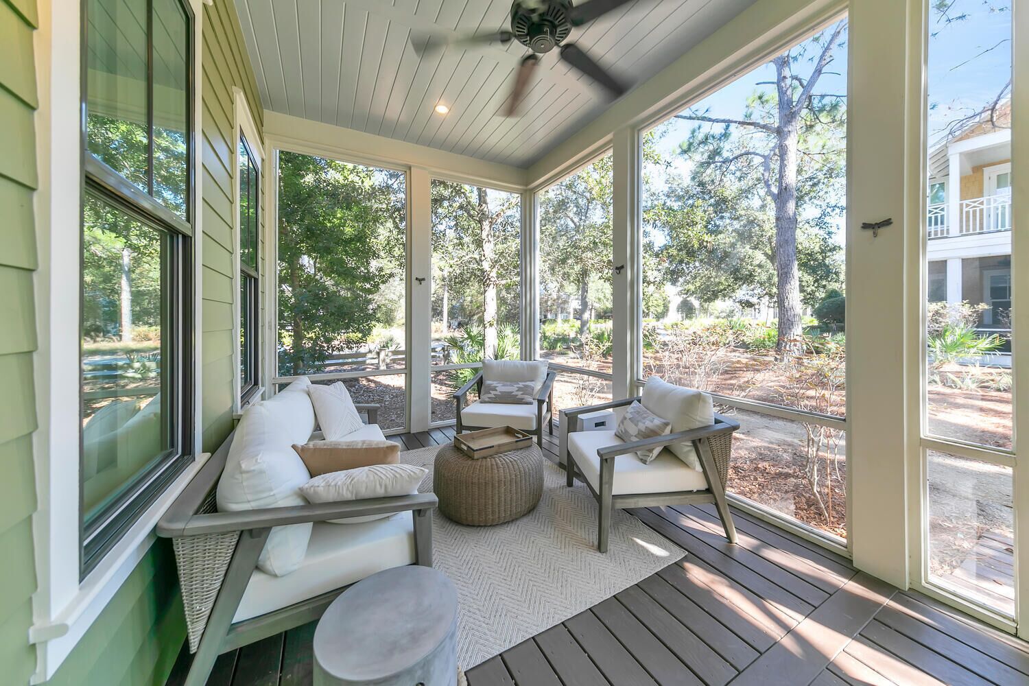 A covered porch with a sofa, chairs, and a small table.