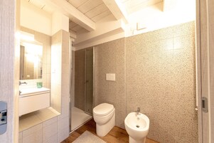 Un bagno moderno con doccia, WC e bidet.