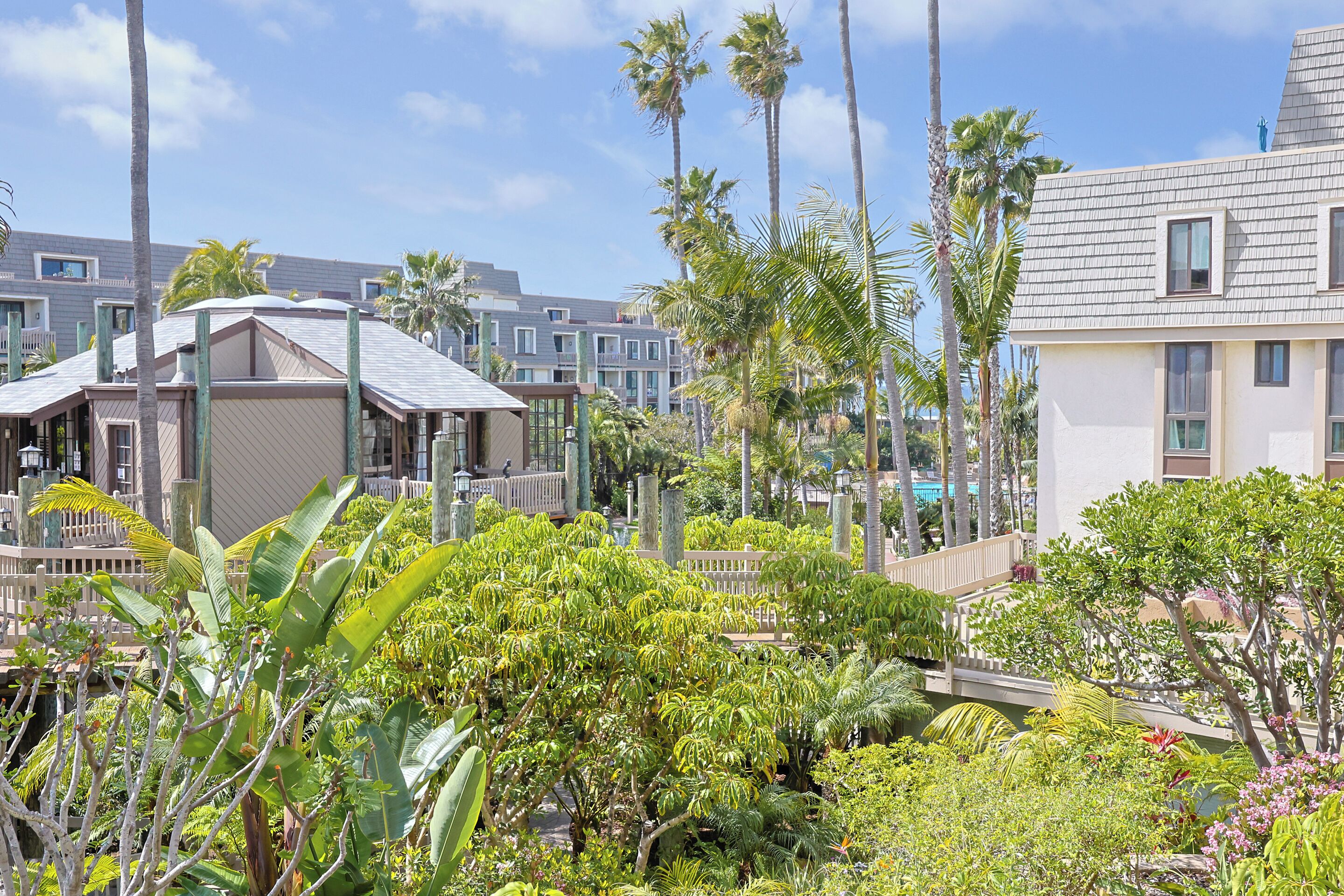 Un resort con diversi edifici, palme e vegetazione lussureggiante.