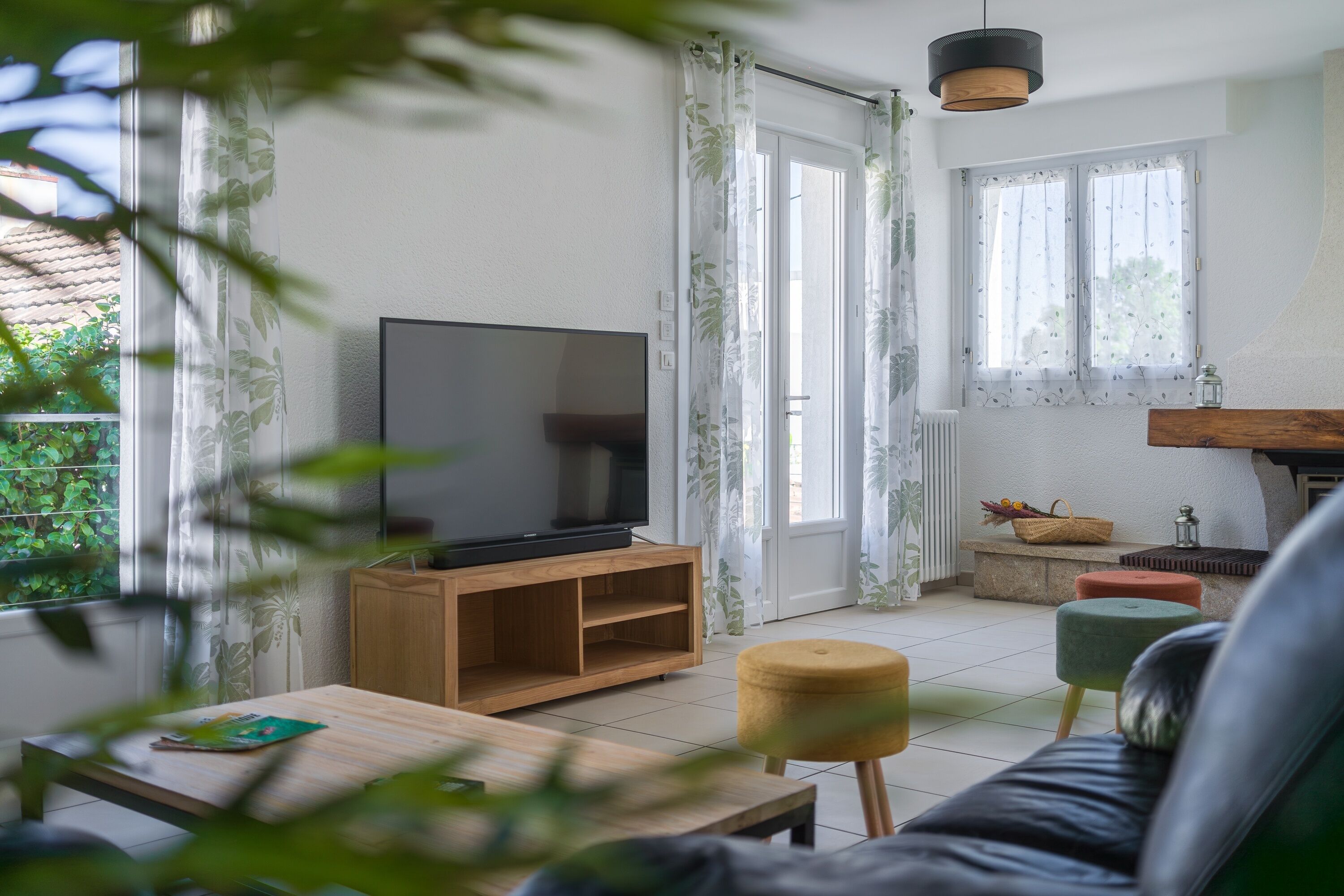 Un salon avec un téléviseur posé sur un meuble en bois, un canapé et une table basse.