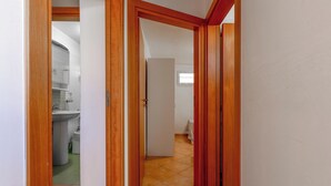 Un pasillo con puertas de madera que dan a un baño y un dormitorio.