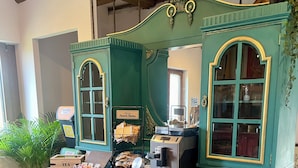 Un meuble de couleur turquoise avec des portes en verre, une machine à café et une enseigne indiquant qu’il s’agit d’un bistrot français.