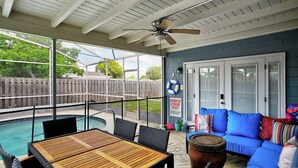 A covered outdoor area with a pool, seating, and a ceiling fan. - Renae Hunt Property (Merritt Island)