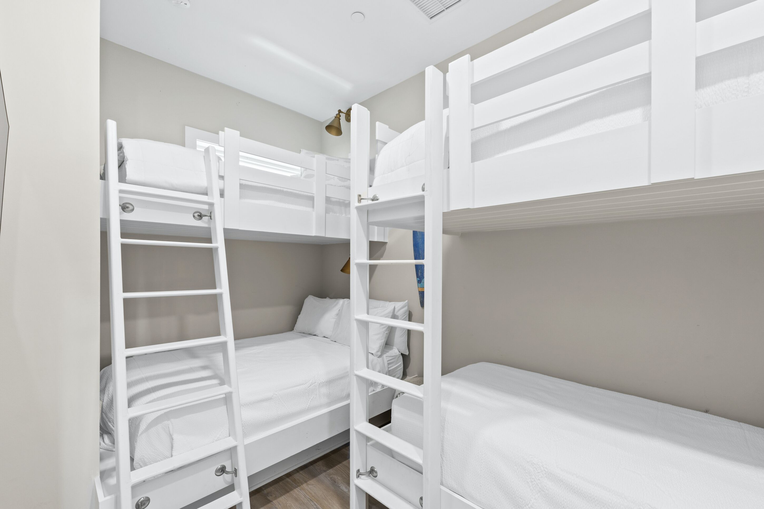 Une chambre avec un lit superposé, une échelle, une petite table et une étagère fixée au mur.