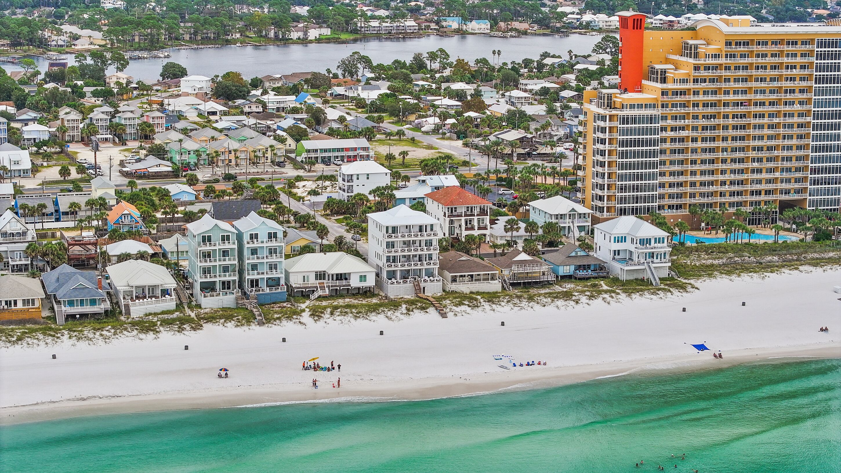 A coastal hotel with multiple floors, beachfront access, and a pool area.