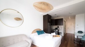A modern hotel room with a bed, a sofa, a dining table, and a kitchenette. - Apto. Abad Najera, en el Centro de Alicante (Alicante (Alacant))