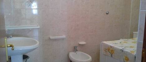 Ein Badezimmer mit Waschbecken, Bidet und Toilette.