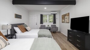 A hotel room with two beds, a TV, a desk, and a chair. - The Lofts on Indian Point (Branson)
