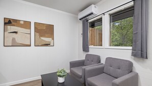 A room with two gray sofas, a black table with a plant, and two abstract paintings on the wall. - The Lofts on Indian Point (Branson)