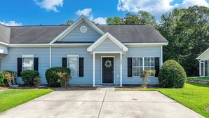 A two-story house with a front porch, a mailbox, and a well-maintained lawn. - Stoney Oasis (Charleston)