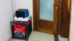 A narrow hallway with a wooden door and a small storage unit with a Star Plus sign. - Charming 1-bed Apartment in Victoria Island, Lagos (Lagos)