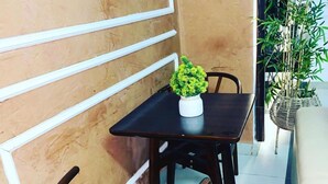 A dining area with a table and chairs, a potted plant, and a wall with a geometric design. - Charming 1-bed Apartment in Victoria Island, Lagos (Lagos)