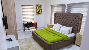 Une chambre avec un grand lit, un bureau et une chaise.
