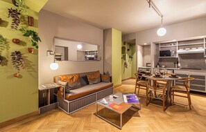 Een gezellig, compacte ruimte met een bank, eettafel en kitchenette.