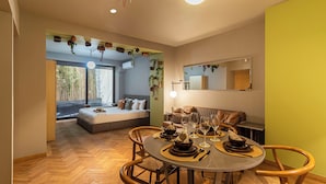 A modern interior with a dining area, a sofa, and a bed with a view.