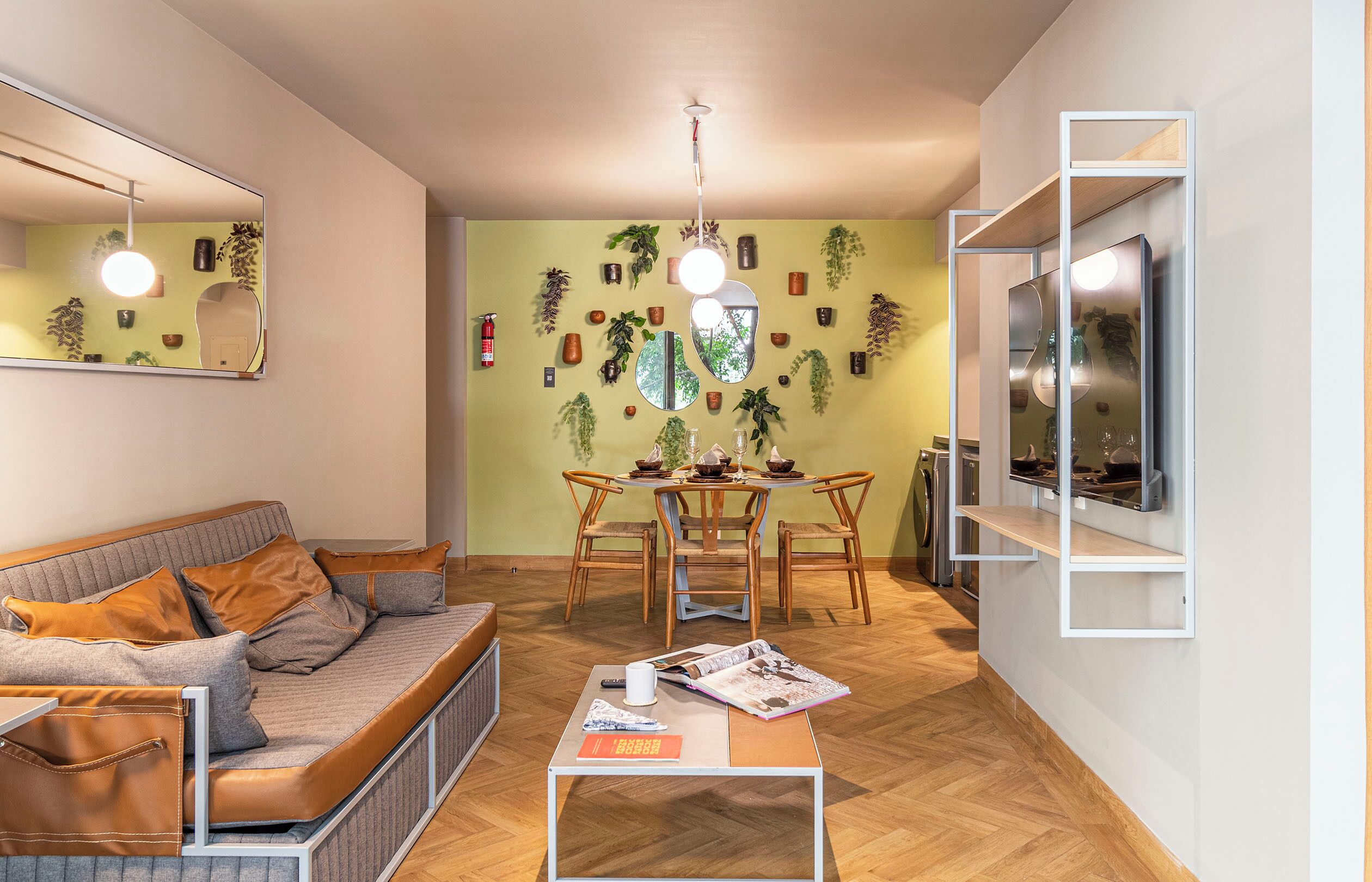 A modern living room with a sofa, coffee table, and a dining area with chairs and a table.