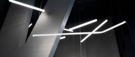 Un interior moderno con luminarias geométricas y paredes de concreto.