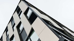 Un bâtiment moderne doté d’une façade géométrique, de grandes fenêtres et d’un toit plat.
