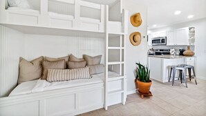 A compact, modern room with a bunk bed, a kitchenette, and a dining area. - Beachwood Villas by Panhandle Getaways (Santa Rosa Beach)