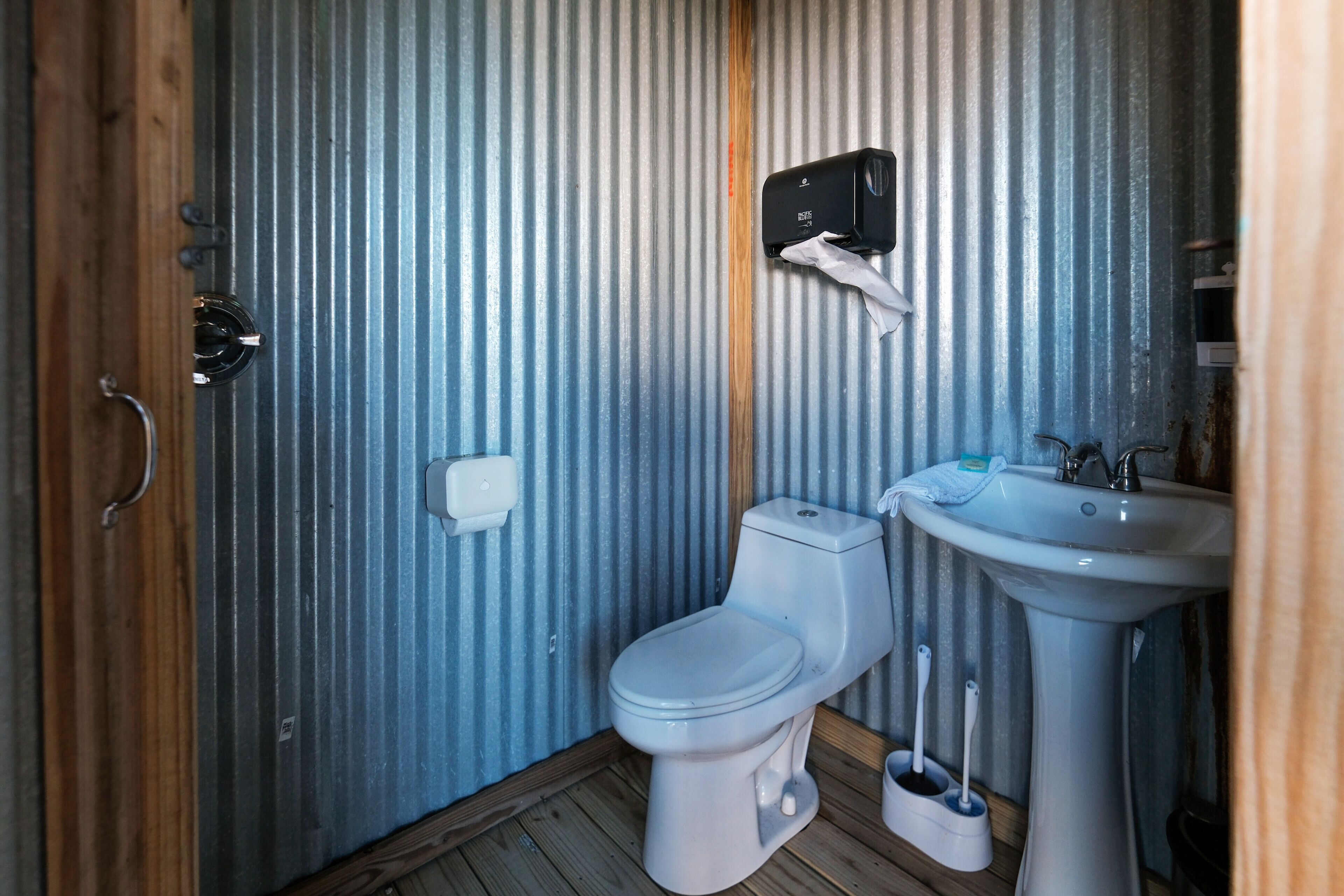 Un baño pequeño con inodoro, lavamanos y secador de manos.