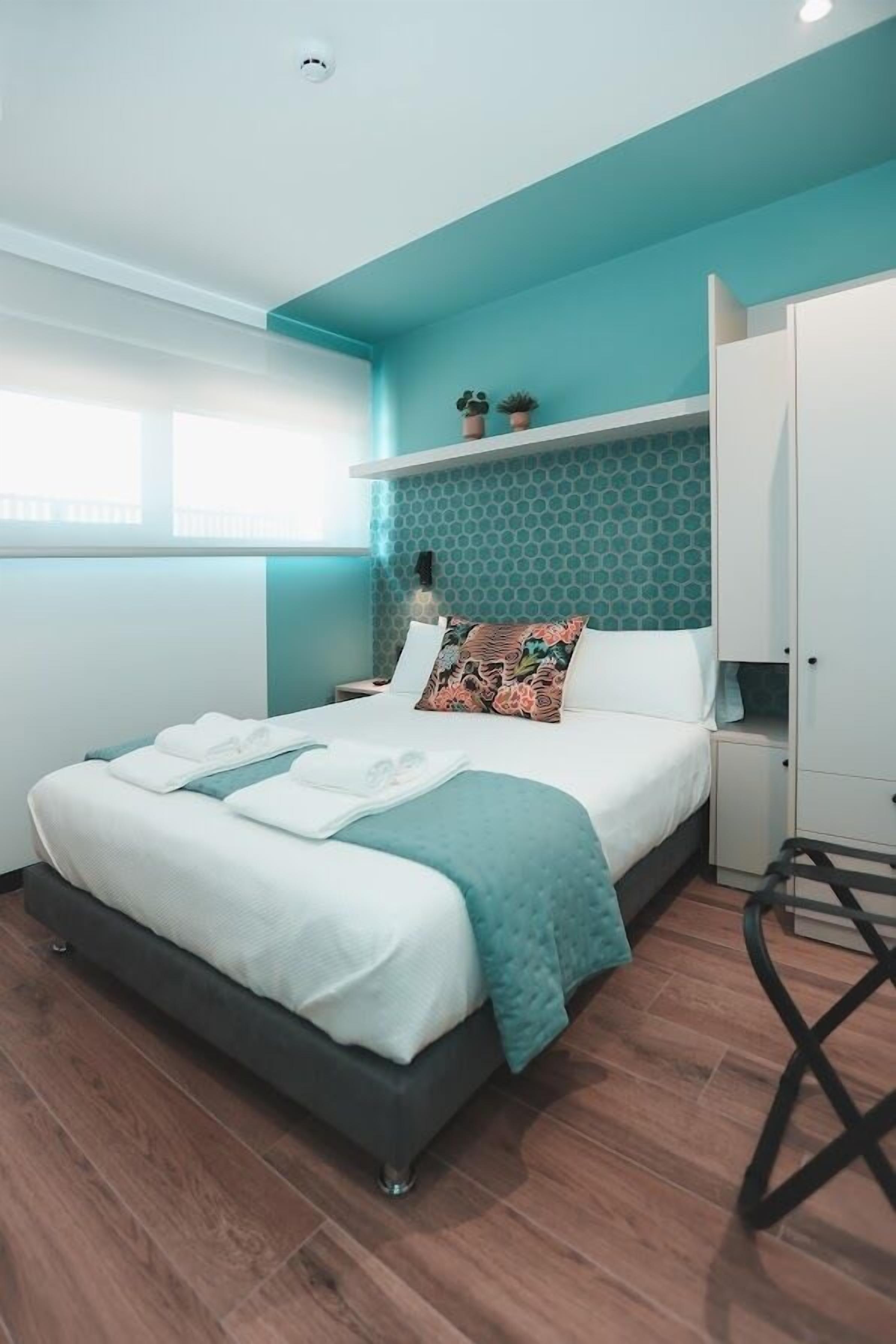 Une chambre à coucher moderne, avec un lit, une armoire et un petit bureau.
