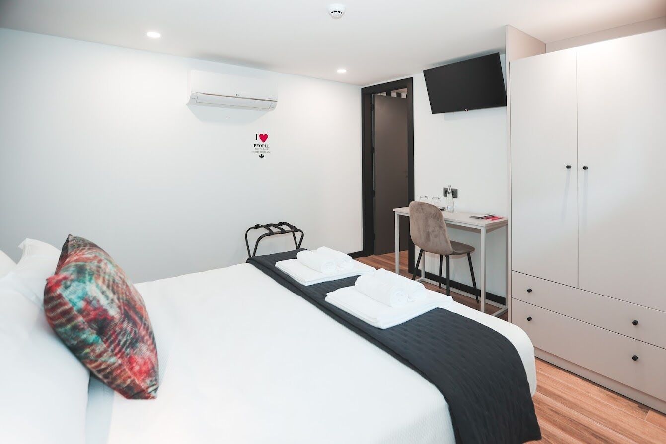Une chambre d’hôtel avec un lit, un bureau et une armoire.