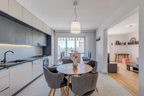 Una cocina moderna con comedor, ventanas amplias y vistas a la ciudad.