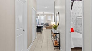 A hallway with a desk, chair, and a bed with a red pillow. - Embark on a Magical Family Getaway:Themed bd, PV Pool, PS5, Air Hockey, Resort (Kissimmee)