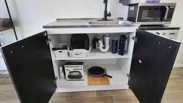 Een koffiezetapparaat/waterkoker, een koelkast, een microgolfoven