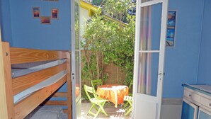 Ein kleines Zimmer mit Etagenbett, Tisch und Stühlen sowie einem Schrank.