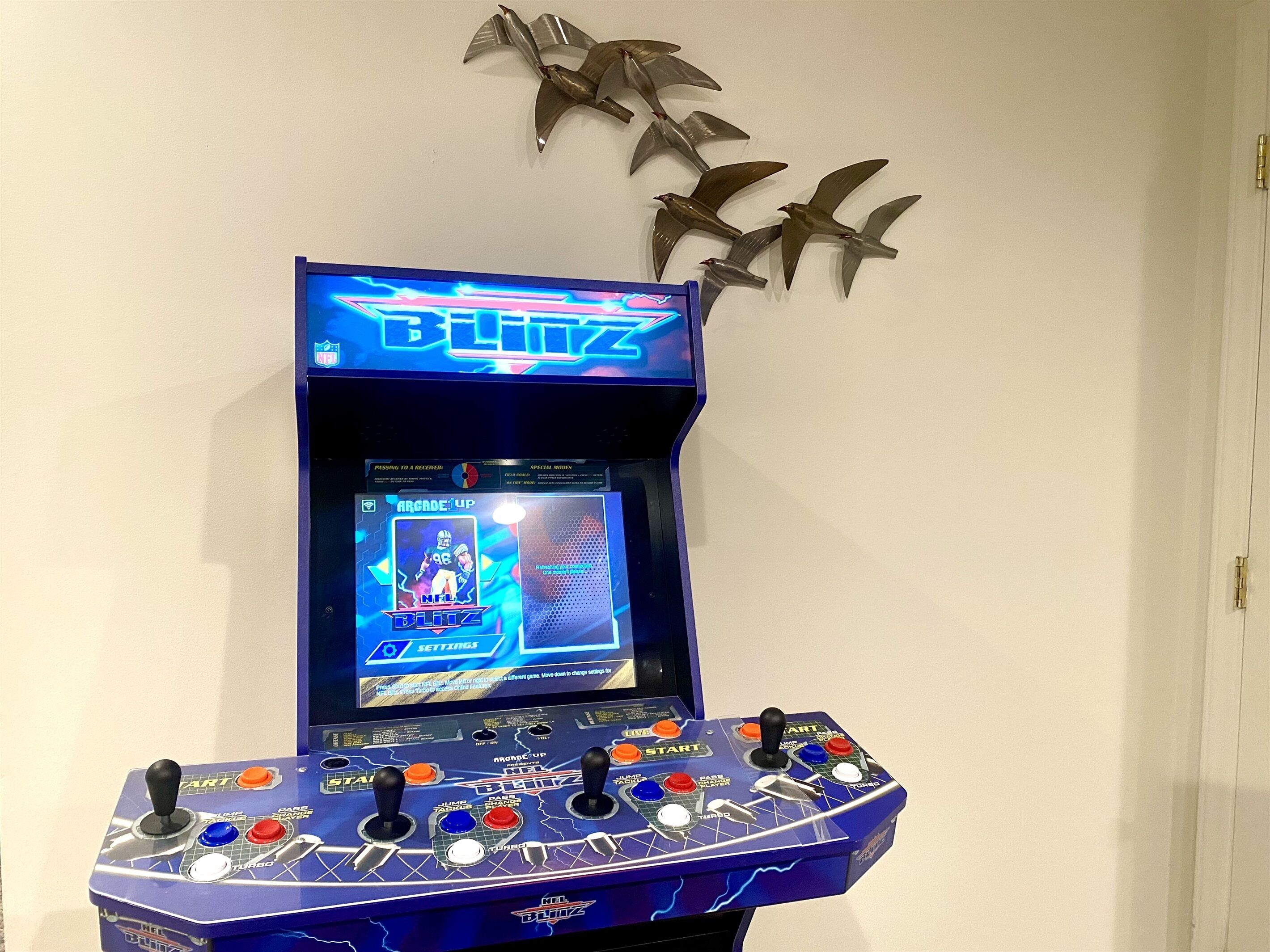 Een speelautomaat voor videogames met meerdere joysticks en een scherm waarop een spel wordt getoond.