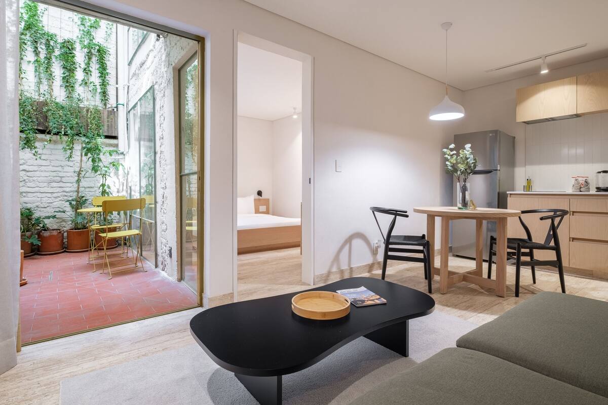 Eine moderne Wohnung mit Essbereich, Küche und einem kleinen Balkon mit Topfpflanzen.
