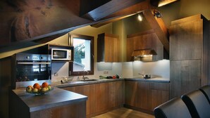 Een moderne keuken met houten kastjes, een inbouwoven en een groot raam.