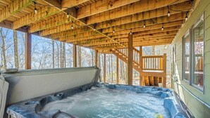 A hot tub under a wooden deck with a view of trees. - Hot Tub EV Charger Pool Dog OK Grill Tennis Hiking (Wintergreen Resort)