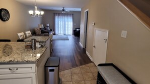 A modern kitchen with granite countertops, a built-in oven, and a stainless steel range hood.