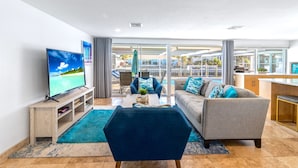 Una sala de estar moderna con televisor, sofá y mesa de centro.
