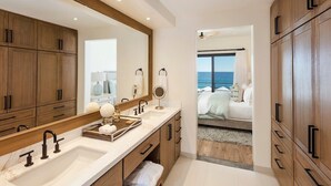 Een moderne badkamer met een grote spiegel, twee wastafels en houten kastjes.