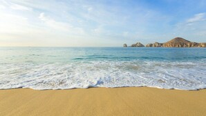 Ein Strand mit klarem, blauem Wasser und sandigem Ufer.