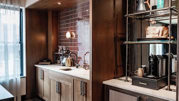 A modern kitchen with wooden cabinets, a stainless steel sink, and a coffee station.