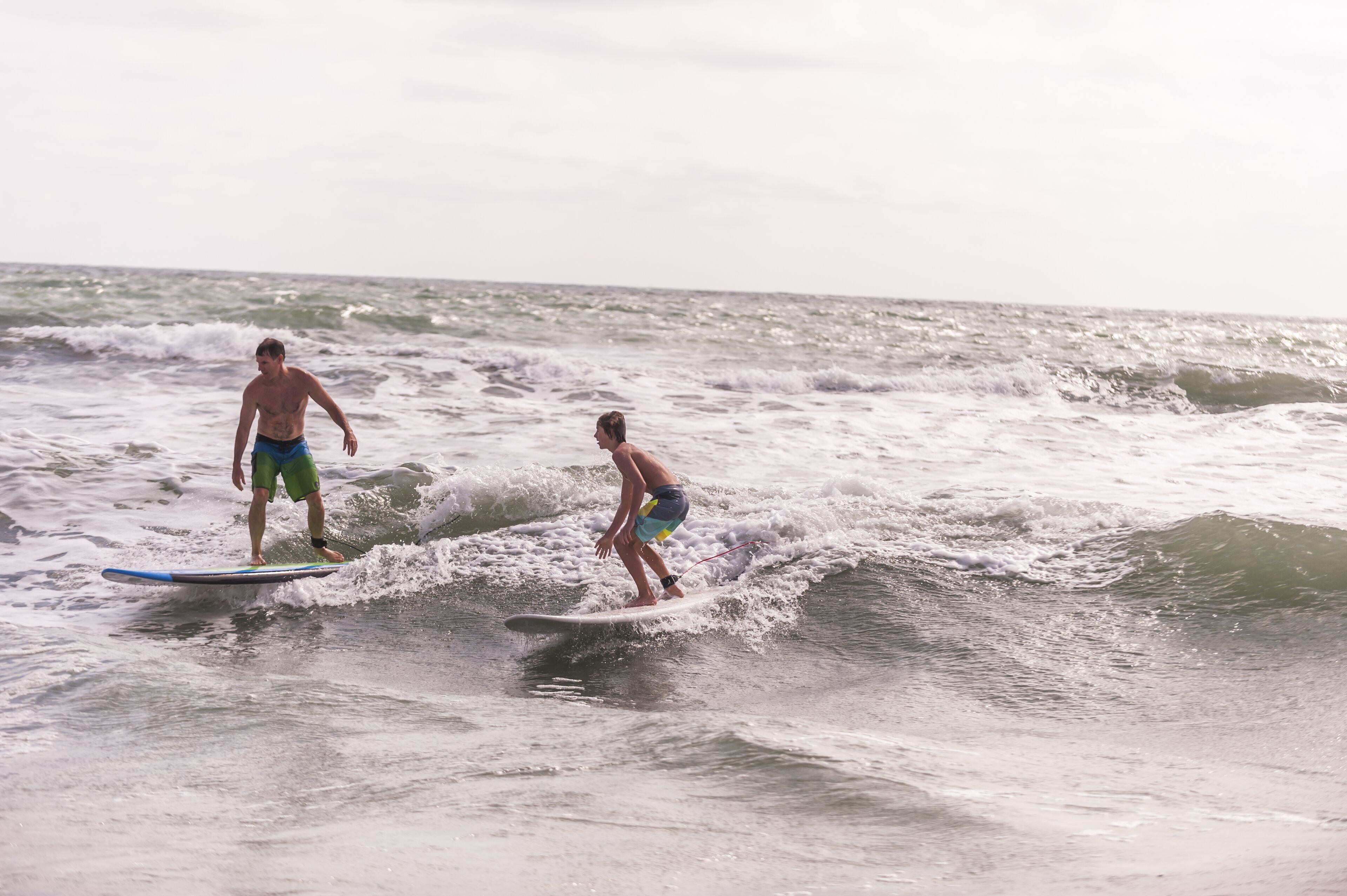 Two people surfing on a wave in the ocean.